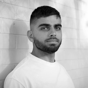 A black-and-white headshot of a man in a white shirt against a white background.